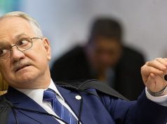 O presidente do Supremo Tribunal Federal, Edson Fachin, sério, segurando microfone, olhando para trás