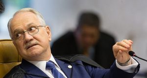 O presidente do Supremo Tribunal Federal, Edson Fachin, sério, segurando microfone, olhando para trás