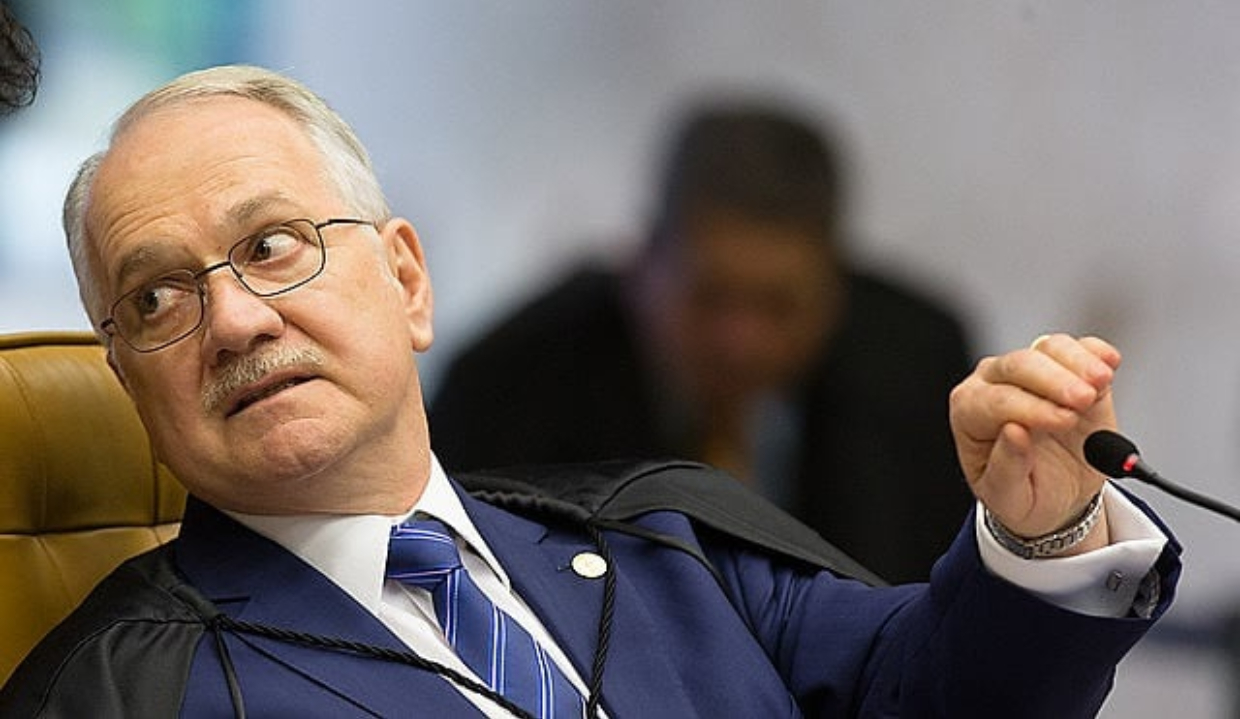 O presidente do Supremo Tribunal Federal, Edson Fachin, sério, segurando microfone, olhando para trás