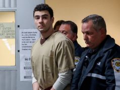 Luigi Mangione acompanhado de agentes