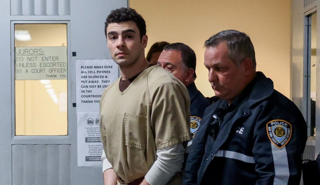 Luigi Mangione acompanhado de agentes