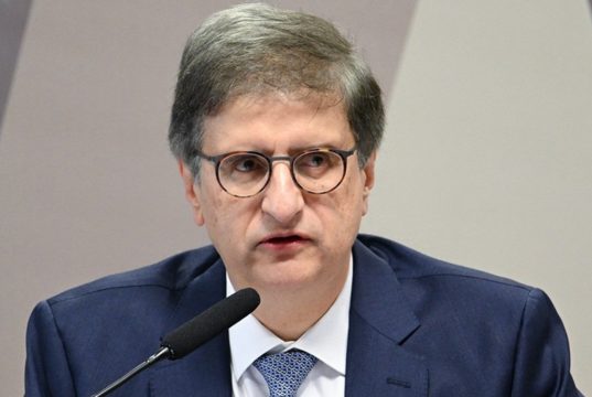 procurador-geral da República, Paulo Gonet, de óculos de grau, falando em microfone, sério, sem olhar para a câmera