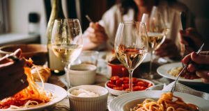 Mesa com vários pratos com comida e taças