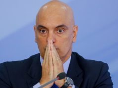 ministro do Supremo Tribunal Federal Alexandre de Moraes sério, com as mãos unidas na frente do rosto, sem olhar para a câmera
