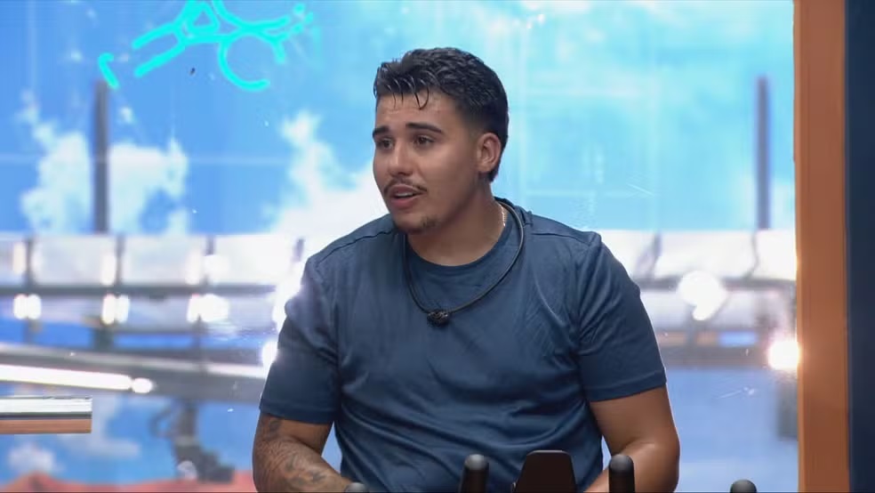 Pedro Espíndola, do BBB 26, com expressão triste, de camiseta, olhando para o lado