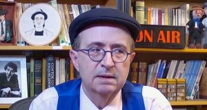 O jornalista Reinaldo Azevedo com expressão pensativa, de óculos de grau e boina, sem olhar para a câmera