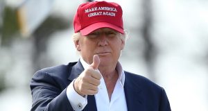 O presidente dos Estados Unidos, Donald Trump, de boné do MAGA, fazendo sinal de joia