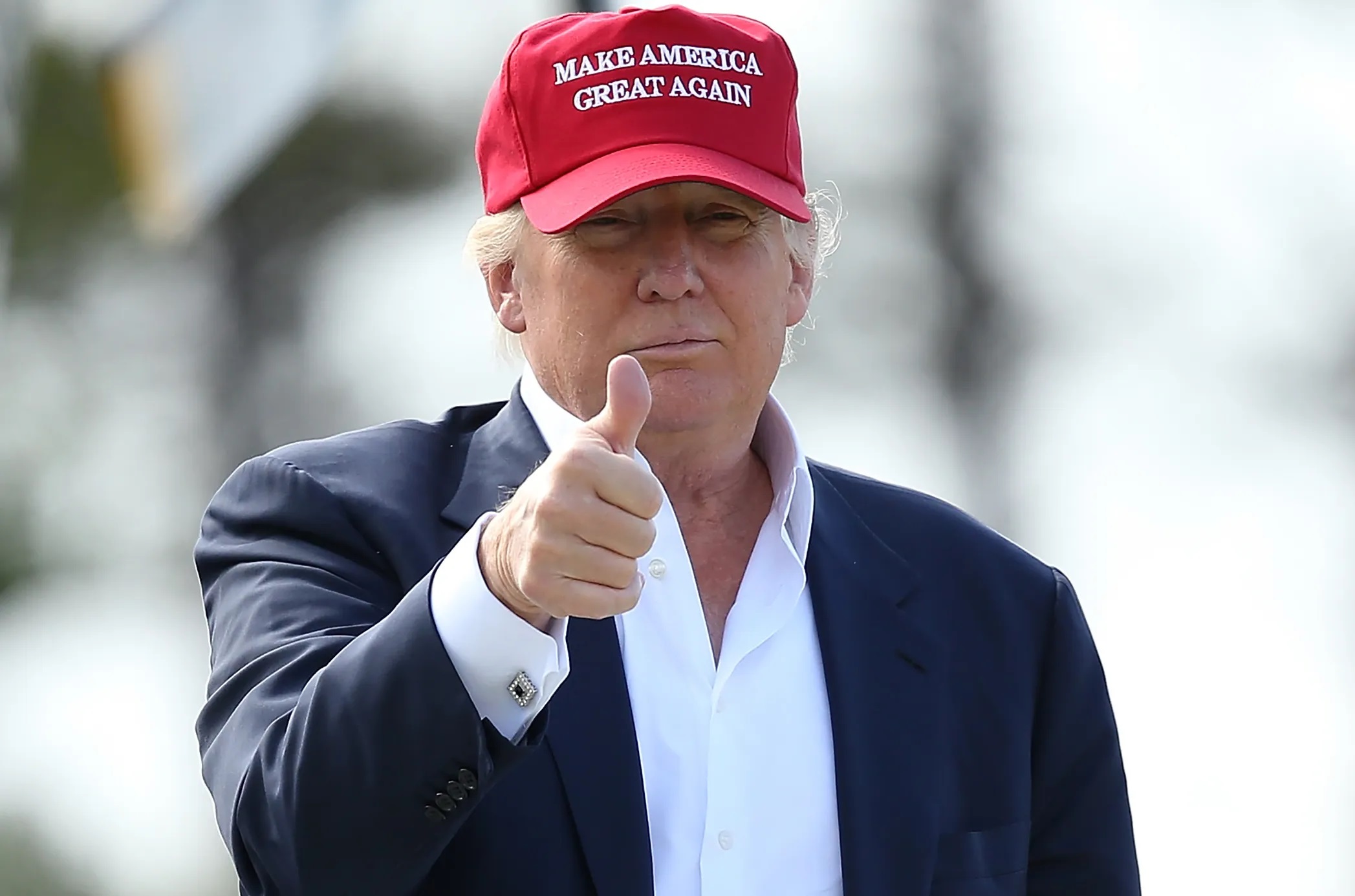 O presidente dos Estados Unidos, Donald Trump, de boné do MAGA, fazendo sinal de joia