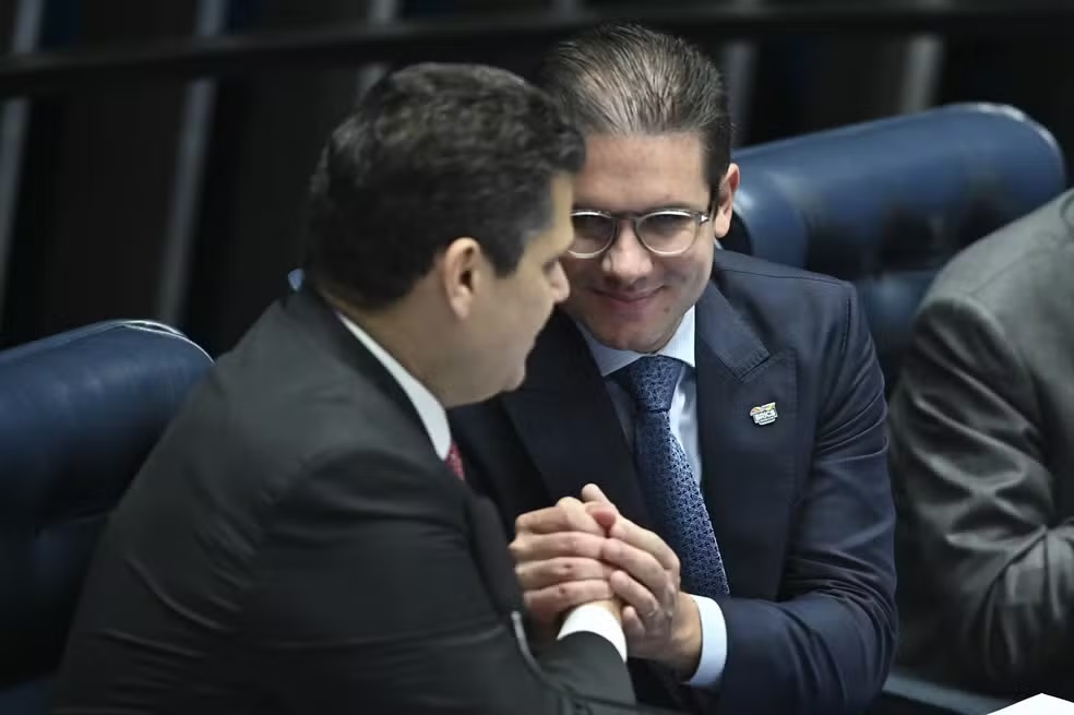 Davi Alcolumbre e Hugo Motta em aperto de mãos, sorrindo