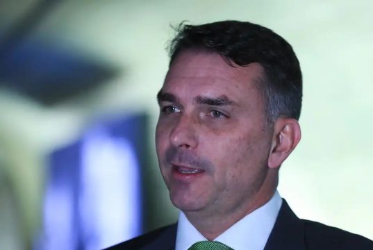 senador Flávio Bolsonaro (PL-RJ) sério, falando, sem olhar para a câmera