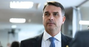 O senador Flávio Bolsonaro (PL) com expressão pensativa, sem olhar para a câmera