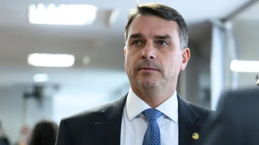 O senador Flávio Bolsonaro (PL) com expressão pensativa, sem olhar para a câmera