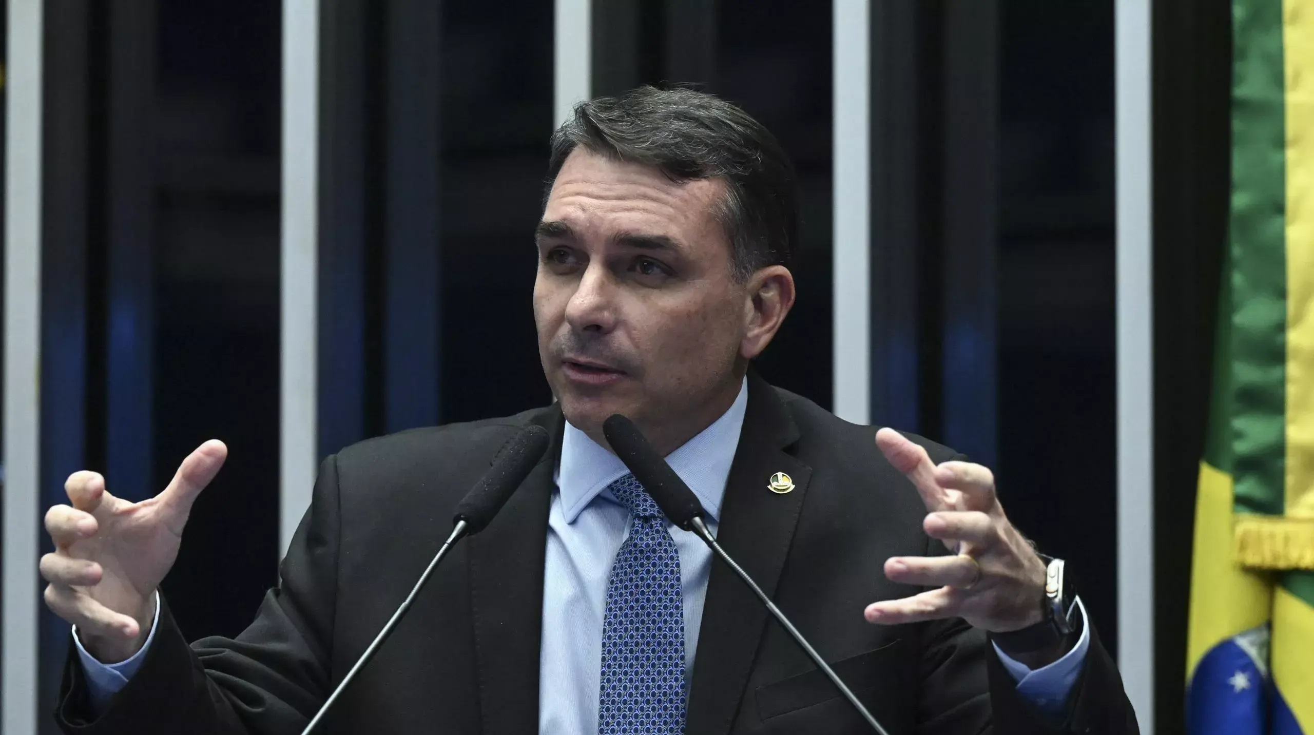 senador Flávio Bolsonaro (PL-RJ) sério, falando e gesticulando