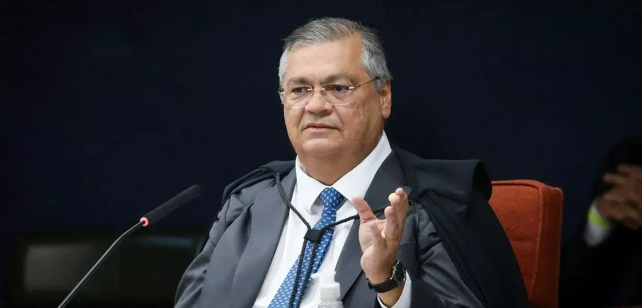 Flávio Dino de óculos, falando sem olhar para a câmera, gesticulando