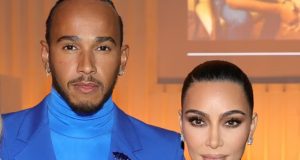 O piloto Lewis Hamilton e a socialite Kim Kardashian posando para foto lado a lado, sérios, olhando para a câmera