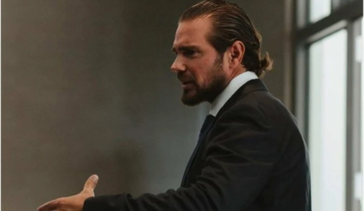 banqueiro Daniel Vorcaro de perfil, de roupa social, falando e gesticulando