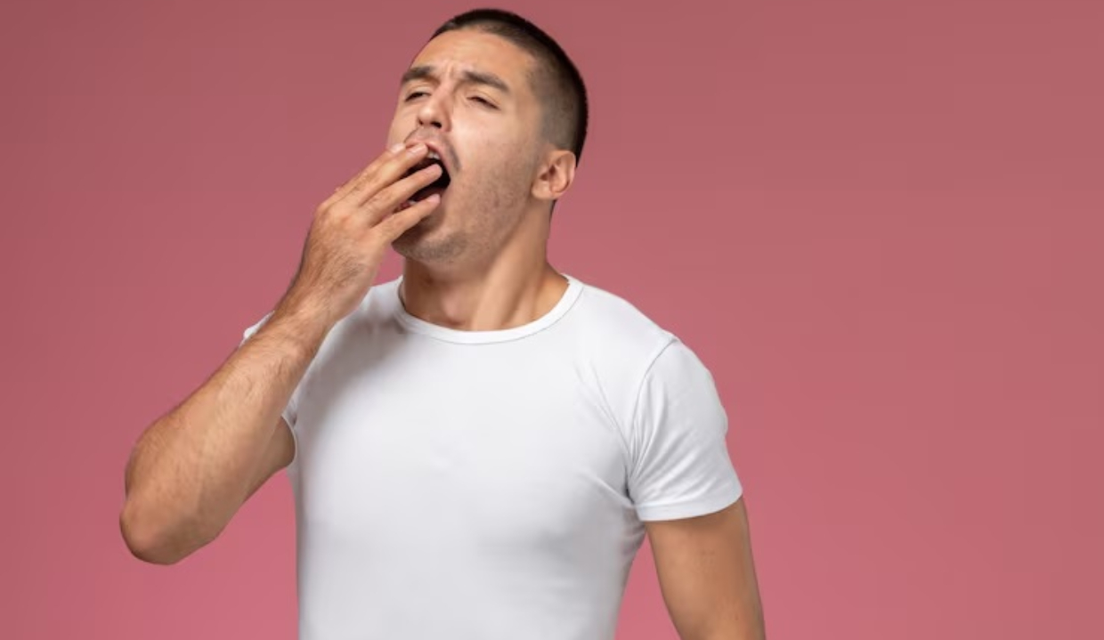 Homem de camiseta branca bocejando