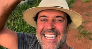 O influenciador Henrique Maderite em close, sorrindo para selfie, de chapéu