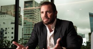 O banqueiro Daniel Vorcaro falando e gesticulando, sem olhar para a câmera, sério