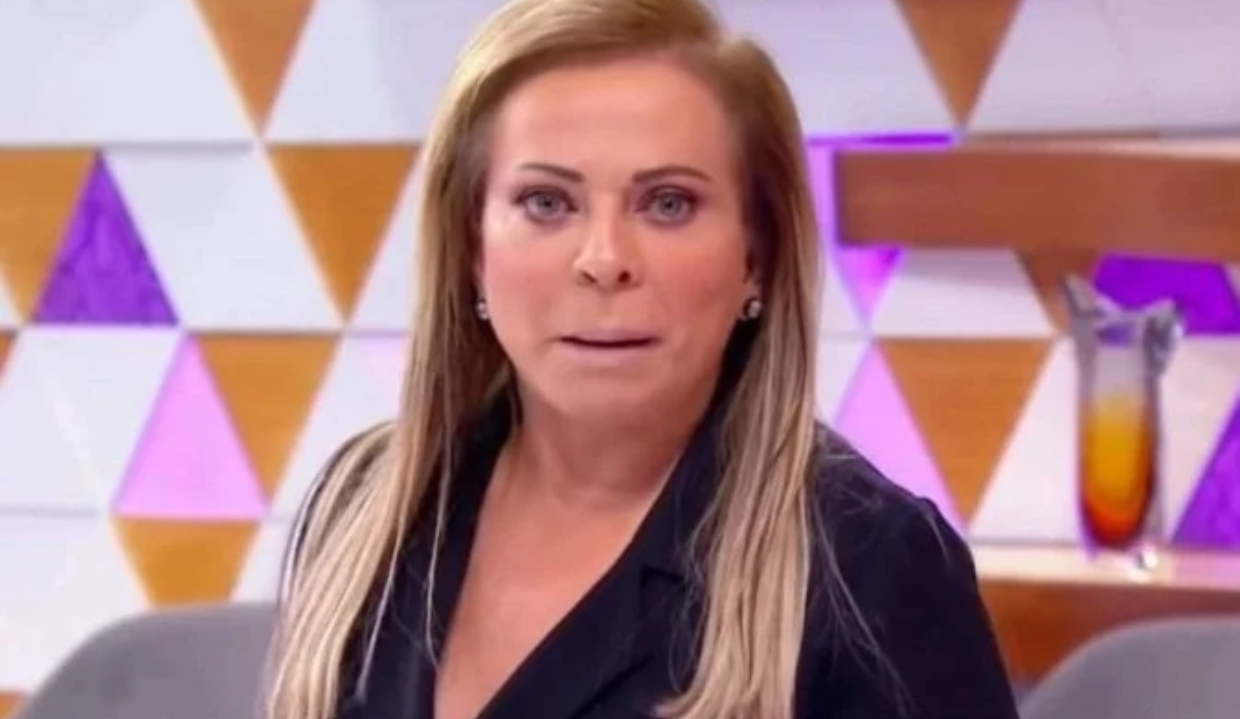 Christina Rocha com roupa escura e cabelo solto, com expressão de espanto