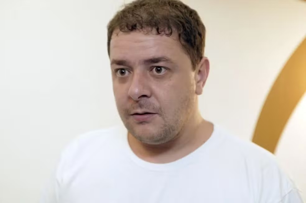 Fábio Luís Lula da Silva, conhecido como Lulinha, de camiseta branca, sério