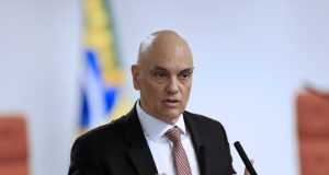 O ministro Alexandre de Moraes falando e gesticulando, sério