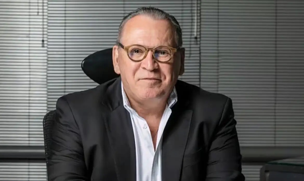 empresário Aparecido Sidney Oliveira sorrindo, de óculos de grau, olhando para a câmera