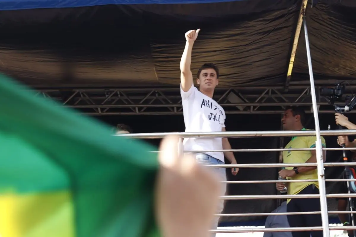 Nikolas Ferreira fazendo joinha em cima de trio elétrico