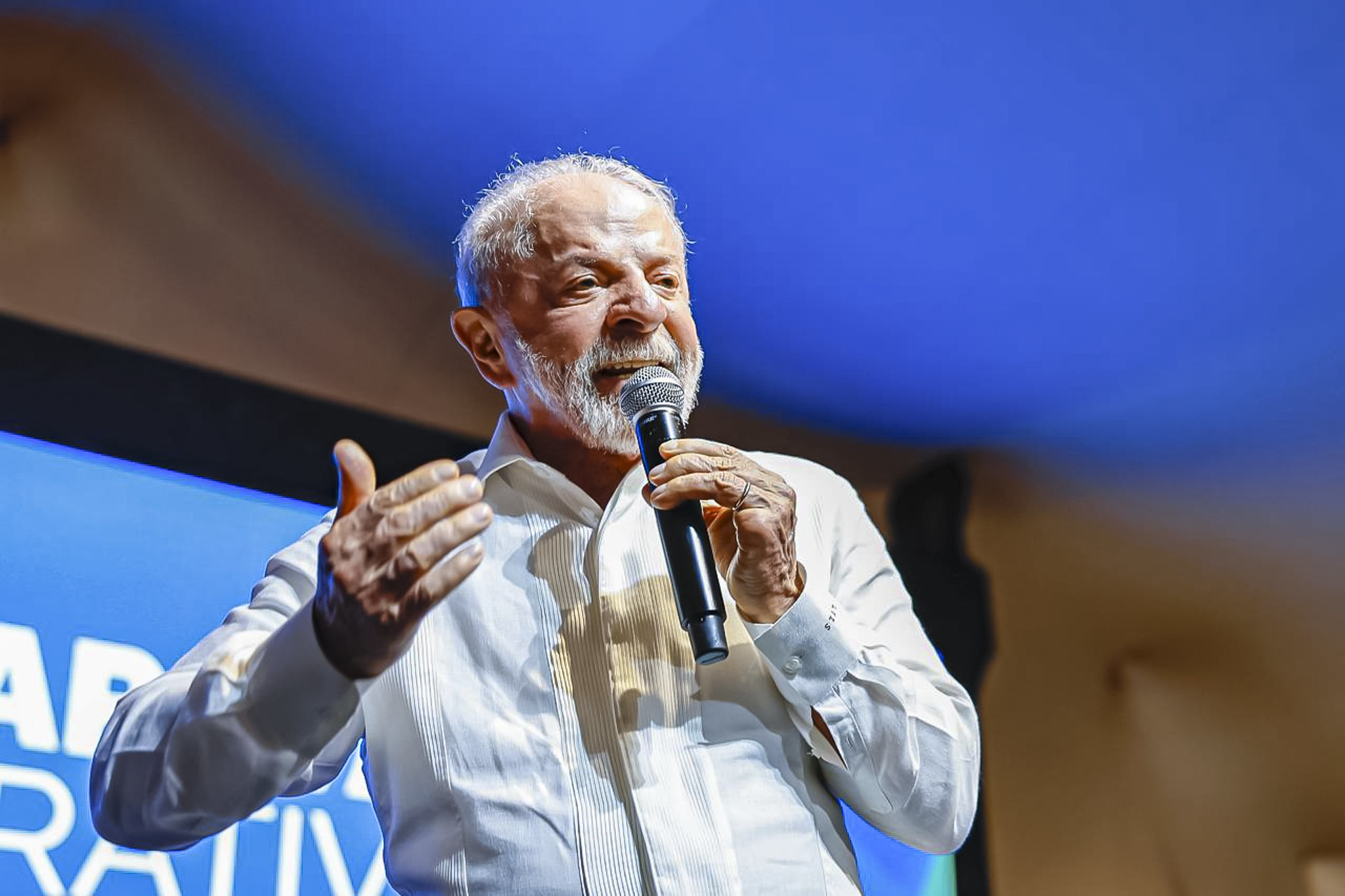 O presidente Luiz Inácio Lula da Silva (PT) de camisa social branca, falando em microfone