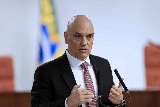 O ministro Alexandre de Moraes, do STF, falando e gesticulando, em pé e sério
