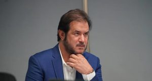 O presidente do União Brasil, Antonio Rueda, sério, com uma das mãos no queixo