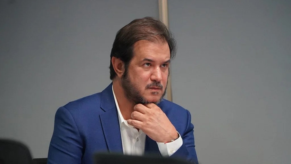 O presidente do União Brasil, Antonio Rueda, sério, com uma das mãos no queixo