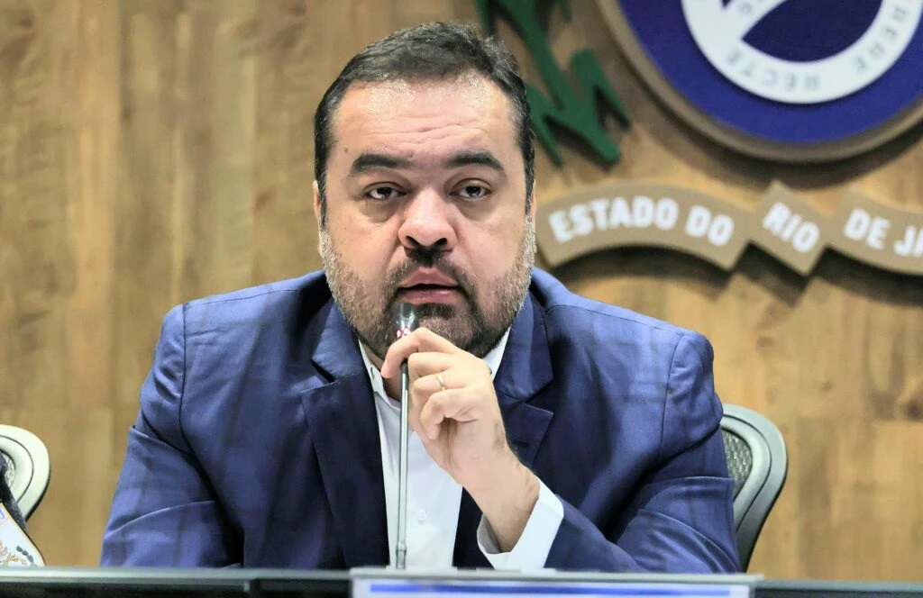 ex-governador do Rio de Janeiro Cláudio Castro com expressão de espanto, segurando microfone