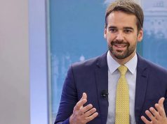 Eduardo Leite falando e gesticulando, no canto direito de foto