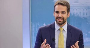 Eduardo Leite falando e gesticulando, no canto direito de foto
