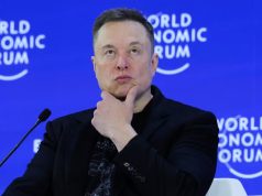 Elon Musk com expressão pensativa e a mão no queixo