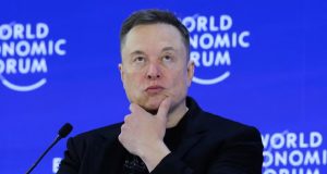 Elon Musk com expressão pensativa e a mão no queixo