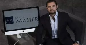 Daniel Vorcaro sentado, sério, ao lado de computador