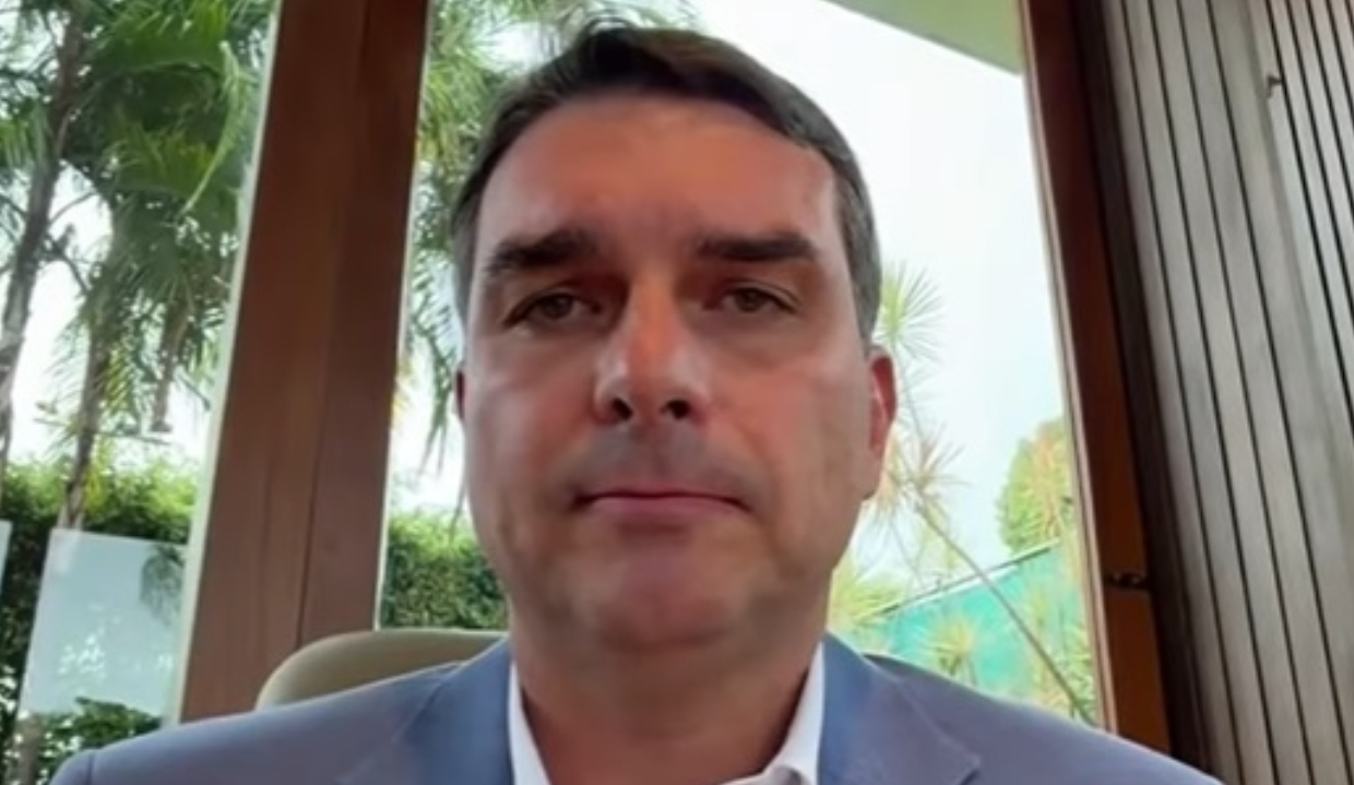 O senador Flávio Bolsonaro (PL-RJ) sério, em close, de roupa social cinza