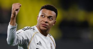 Kylian Mbappé correndo em campo com uniforme do Real Madrid