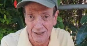 Marcos Oliveira de camisa polo amarela e boné cinza, falando para a câmera