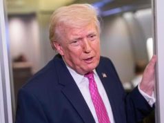 O presidente Donald Trump em pé, falando, de roupa social