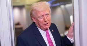 O presidente Donald Trump em pé, falando, de roupa social