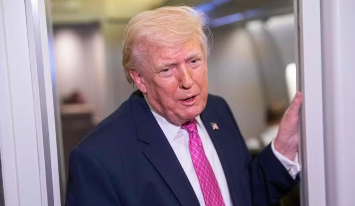 O presidente Donald Trump em pé, falando, de roupa social