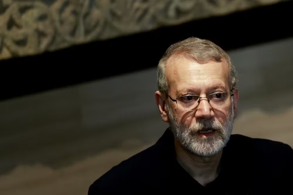 Ali Larijani, chefe do Conselho Supremo de Segurança do Irã, sério, em canto direito de foto, de óculos