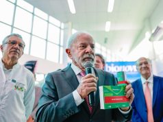 O presidente Luiz Inácio Lula da Silva (PT) segurando caixas de remédio e falando em microfone