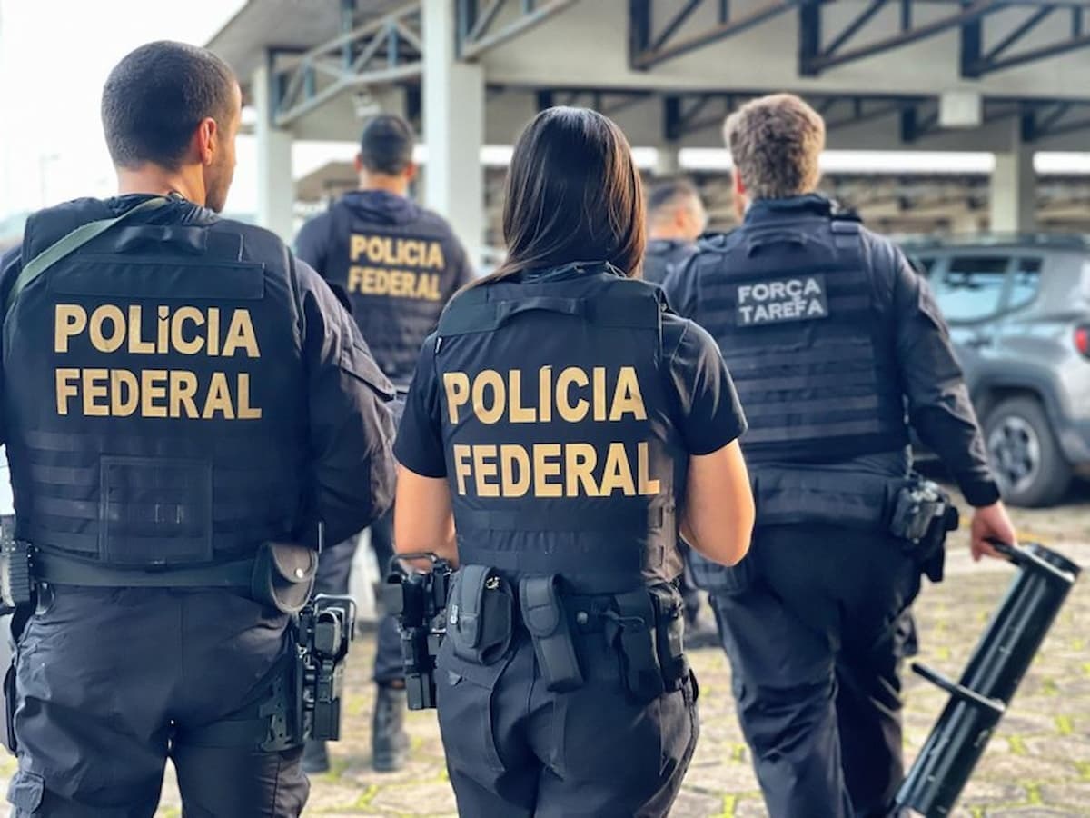 Agentes da Polícia Federal em pé, de costas