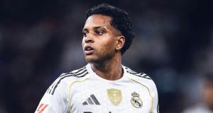 jogador brasileiro Rodrygo Goes de uniforme, olhando para trás, sério