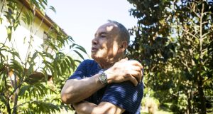 Stênio Garcia de braços cruzados, falando, em pé, de perfil