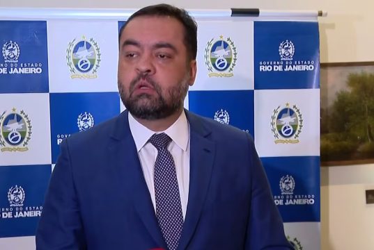 Cláudio Castro falando, sério, sem olhar para a câmera